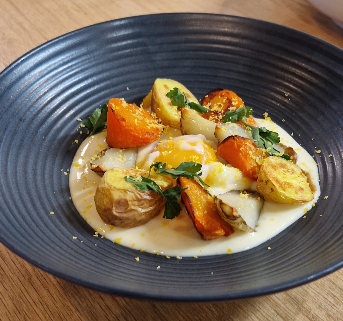 Assiette sombre avec légumes rôtis et sauce claire